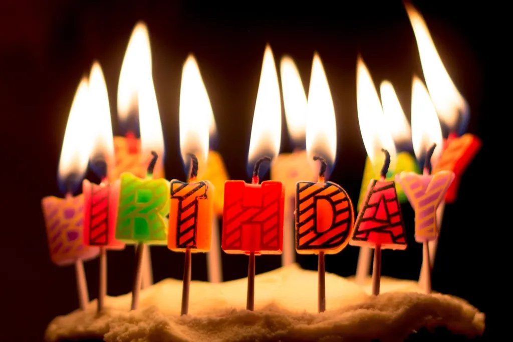 Lit birthday candles spelling out BIRTHDAY